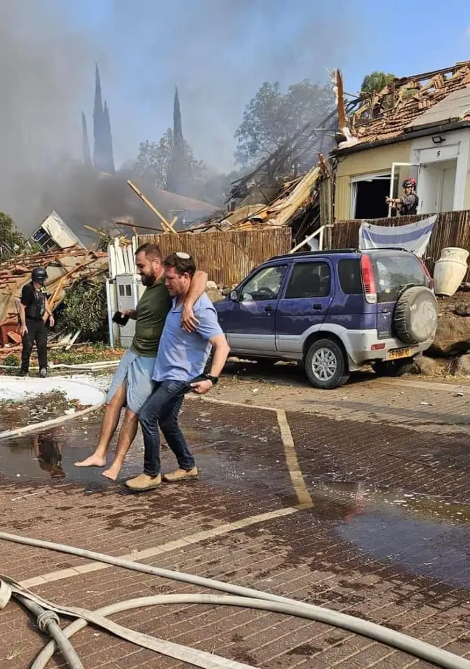 Golan Regional Council Governor Uri Kellner bringing a Golan Heights citizen to safety after rescuing him from his burning house. The home was hit by a Hezbollah rocket during this morning's Hezbollah missile attack on northern Israel. (From Dov Lipman)
